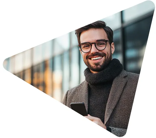 lächelnder Mann mit Brille und Schal vor einem modernen Bürogebäude